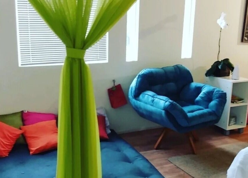 Espaço acolhedor KBzen com poltrona azul e almofadas coloridas. Cotia, São Paulo, BR.