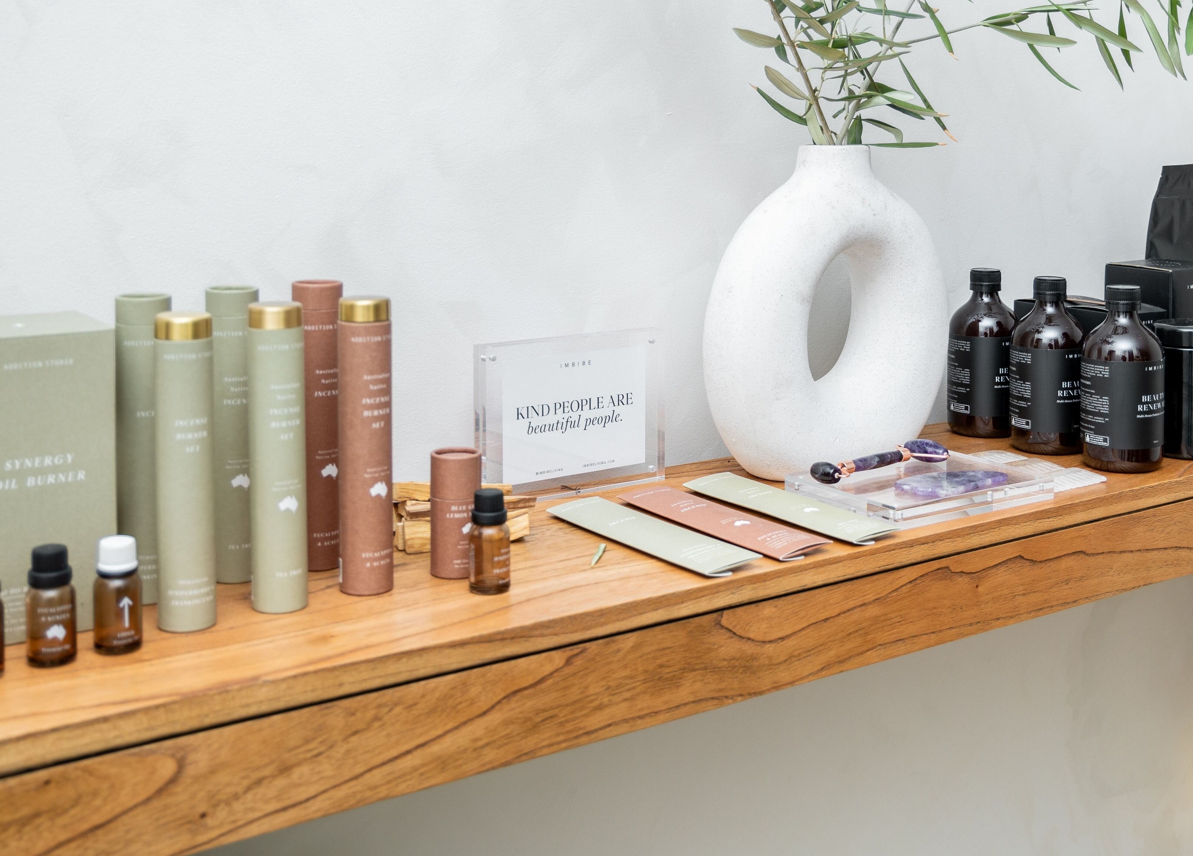 Wellness products on wooden shelf at Surskin, Perth, Western Australia, AU. Includes oils and incense.