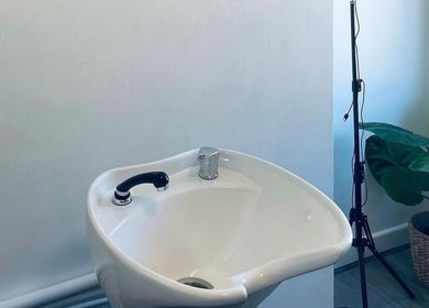 Modern salon sink setup at Paije Love Hair, Rainhill, England, GB with sleek design and potted plant.