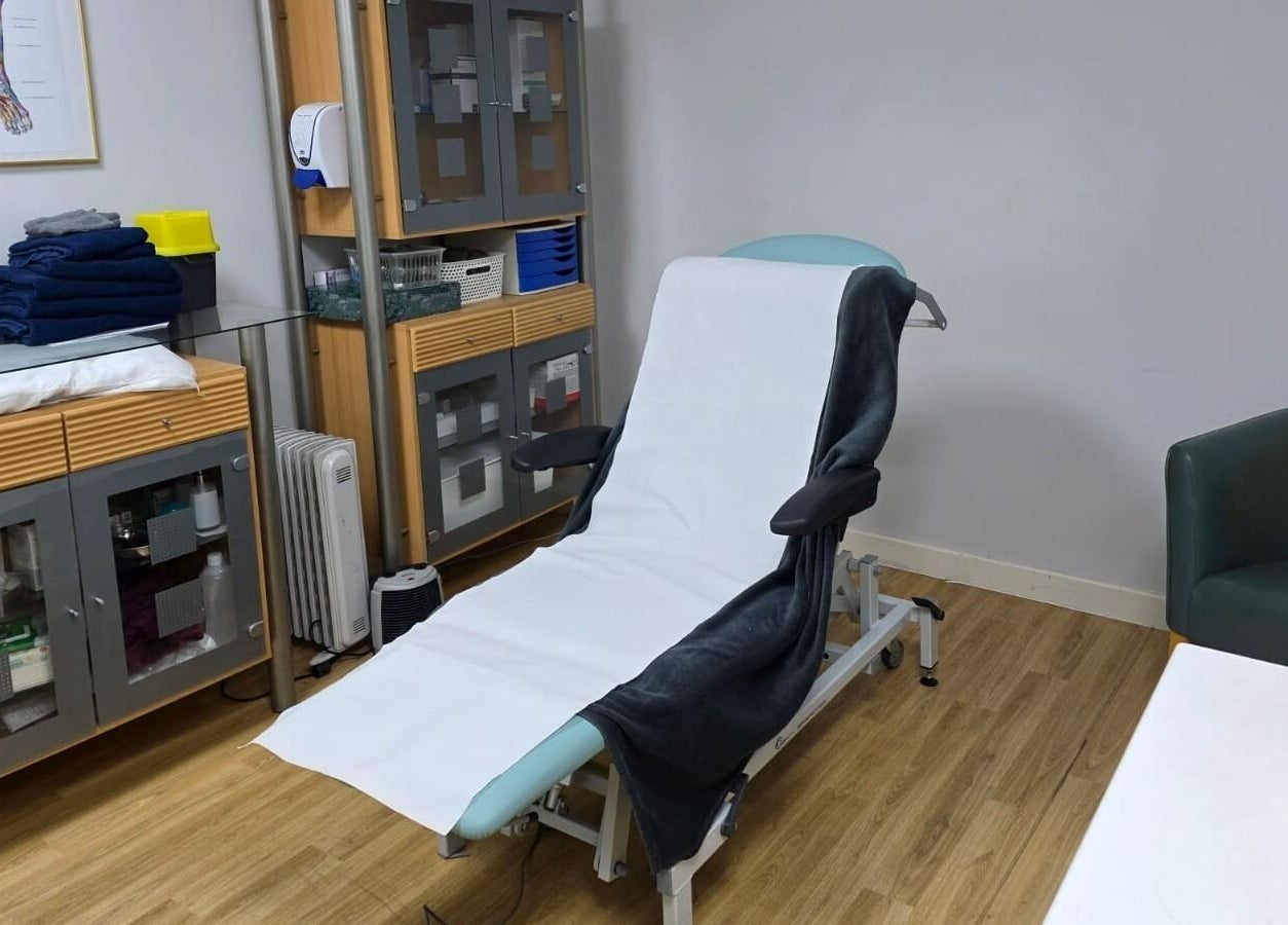 Relaxing treatment room at All Being Well Health & Acupuncture, Ilkeston, England, GB with comfy chair and cabinets.