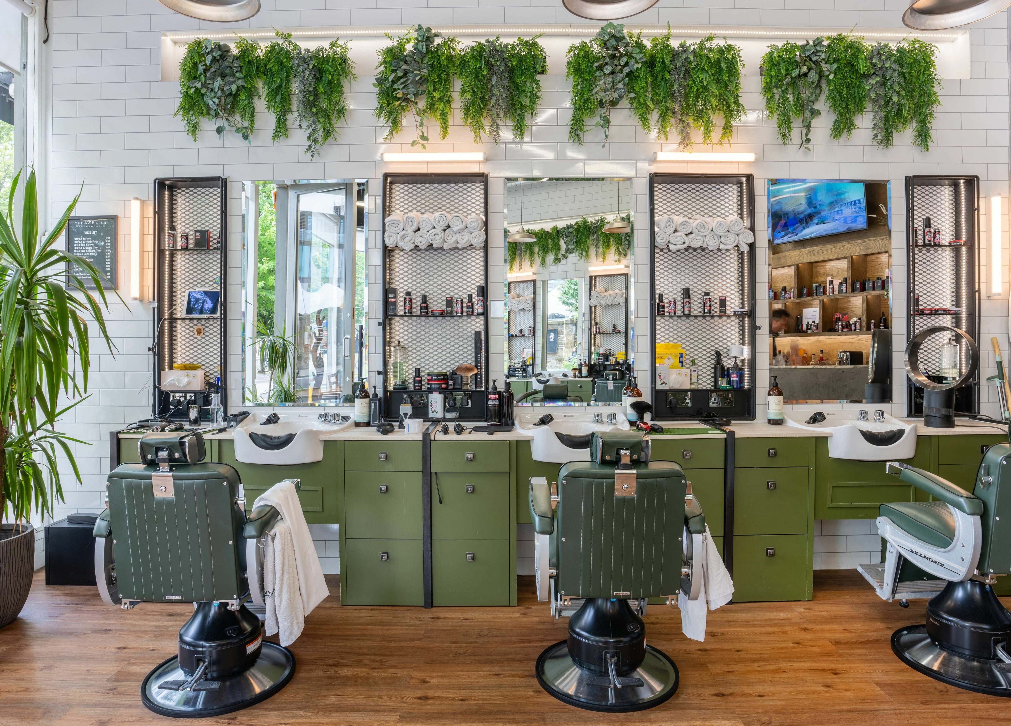 Stylish barber chairs and lush decor at The Axe Club in Camden, London, England, GB.