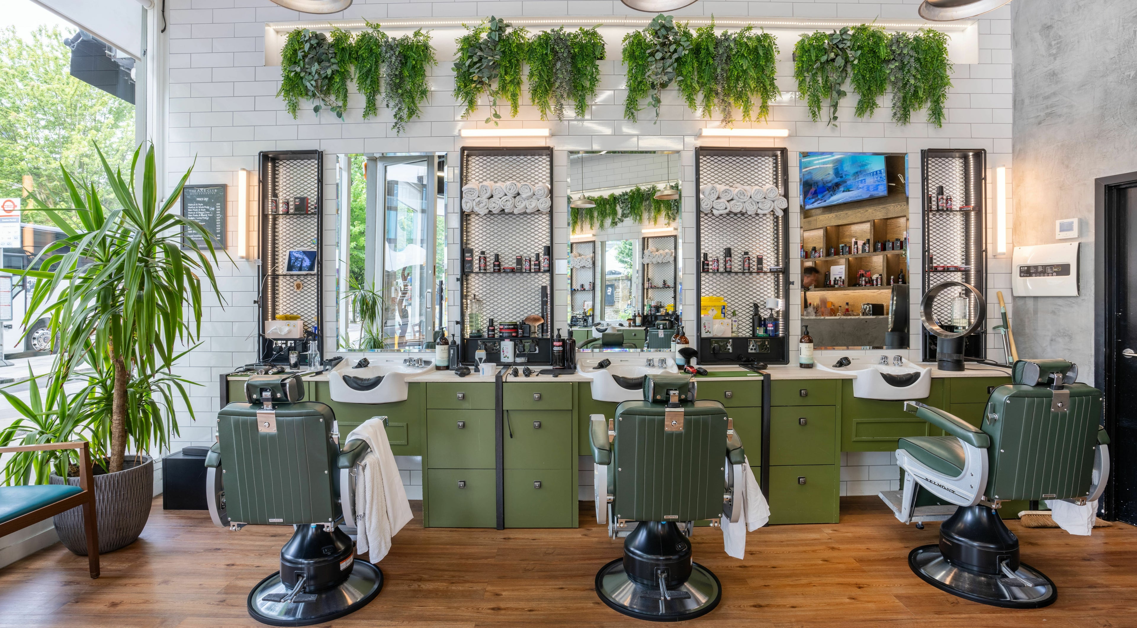 Stylish barber chairs and lush decor at The Axe Club in Camden, London, England, GB.
