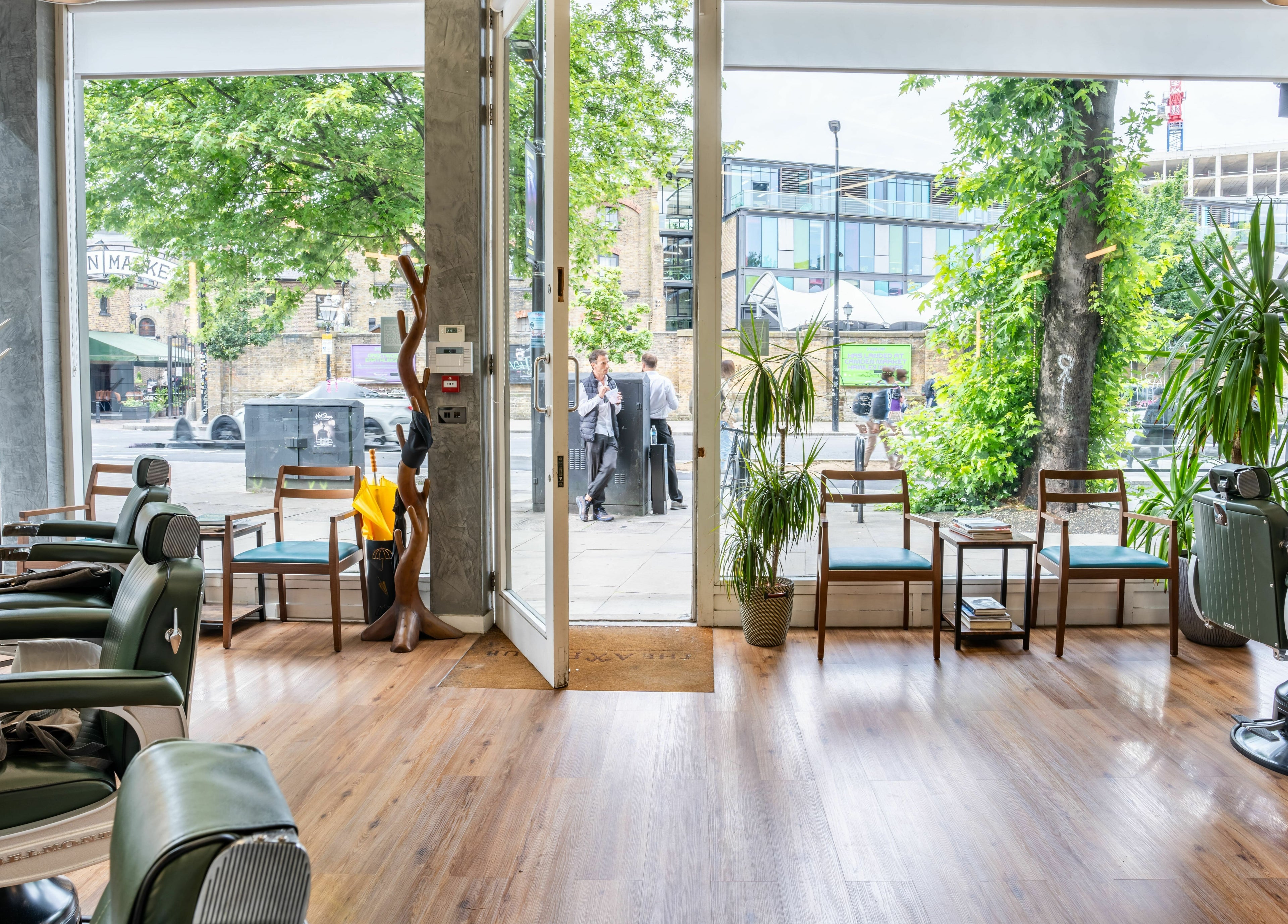 Elegant salon interior at The Axe Club in Camden, London, England, GB with stylish chairs and lush plants.