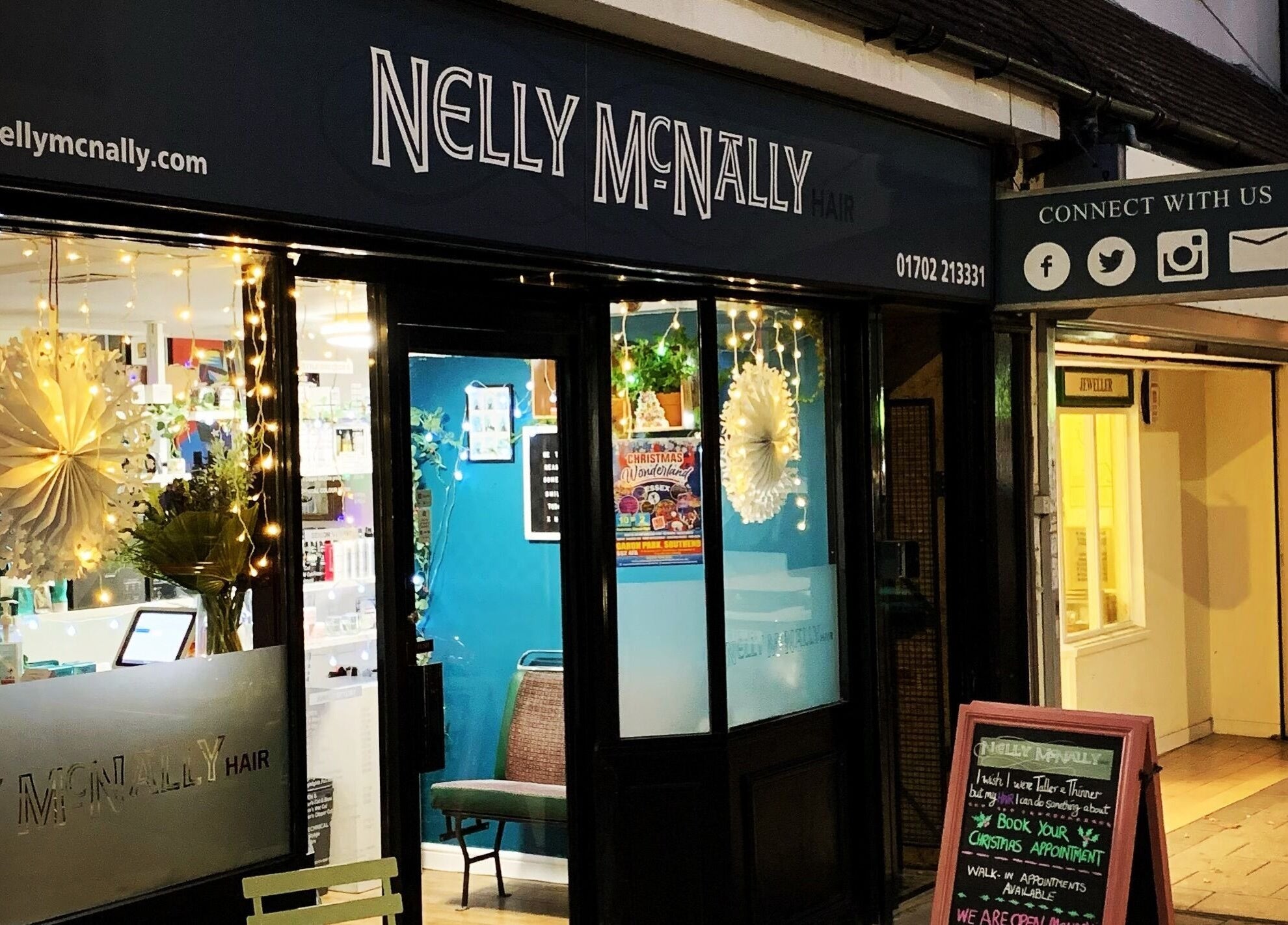 Exterior of Nelly McNally, a stylish beauty venue in Southend-on-Sea, England, GB, warmly lit at night.