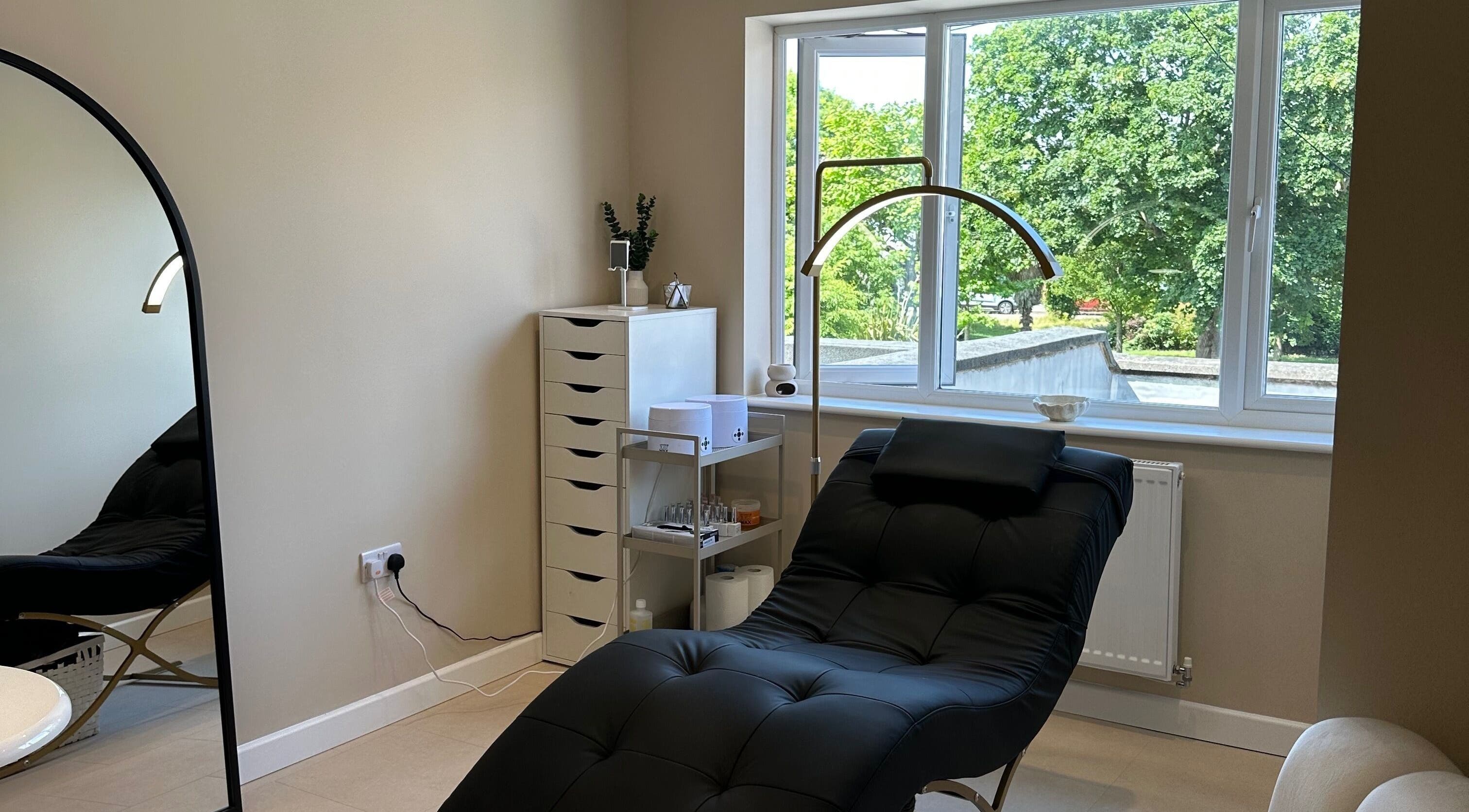 Relaxing treatment room at SO • SUITE, Fareham, England, GB featuring a comfy black chair and serene decor.
