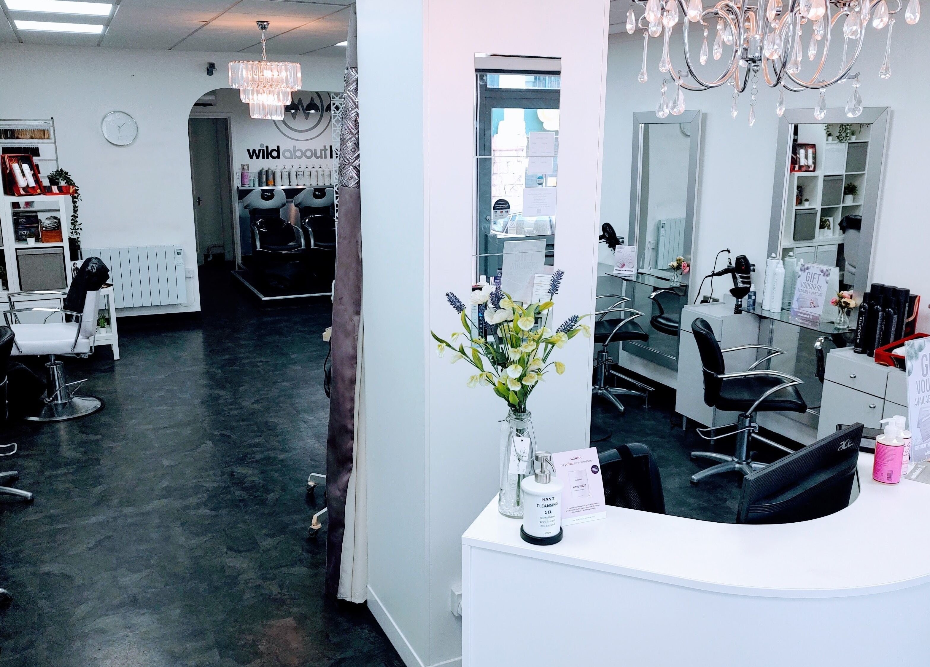 Chic interior of Wild About Hair, Torquay, England, GB. Stylish black chairs and modern decor create a welcoming ambiance.