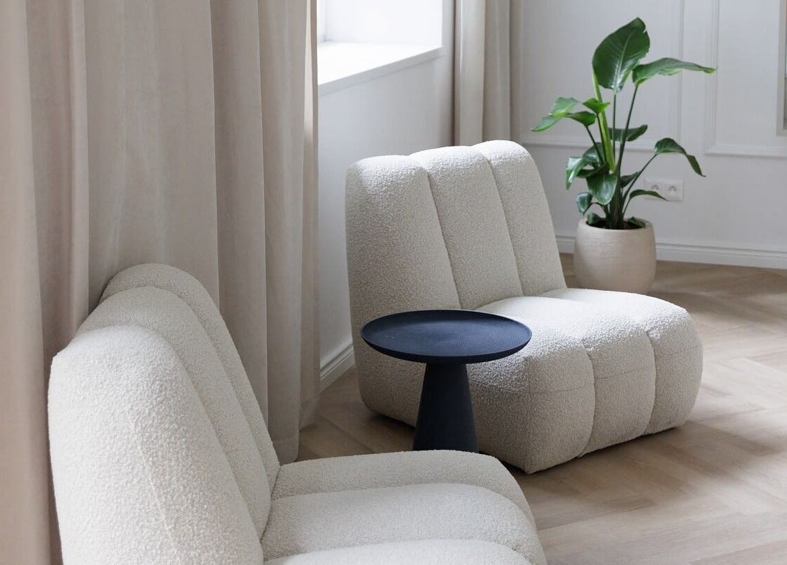 Stylová místnost Amati Room v Bratislava, Bratislavský Kraj, SK s moderními křesly a rostlinou.