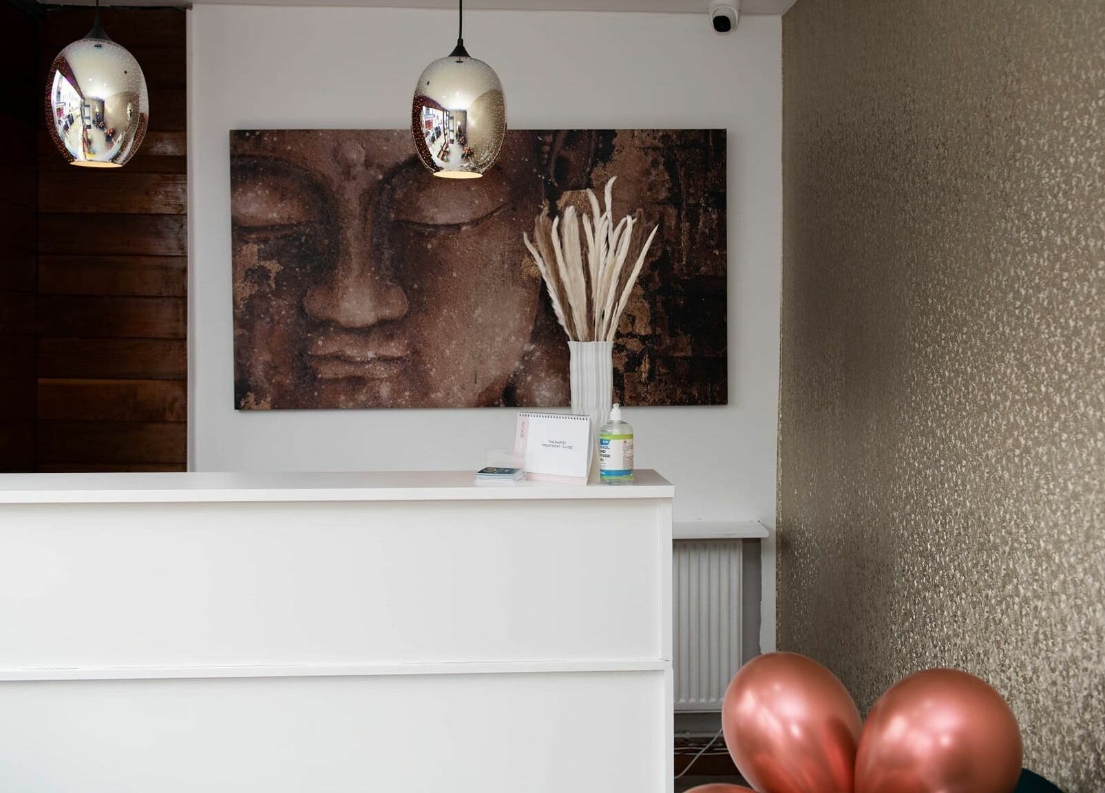 Reception area of Oasis Spa Therapy in WORTHING, England, featuring calm decor and a serene Buddha painting.