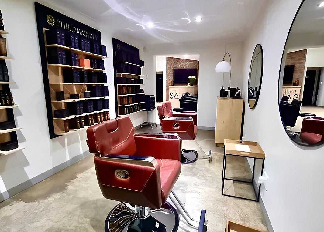 The Barber's stylish interior in Bloemfontein, Free State, ZA with red chairs and product displays.