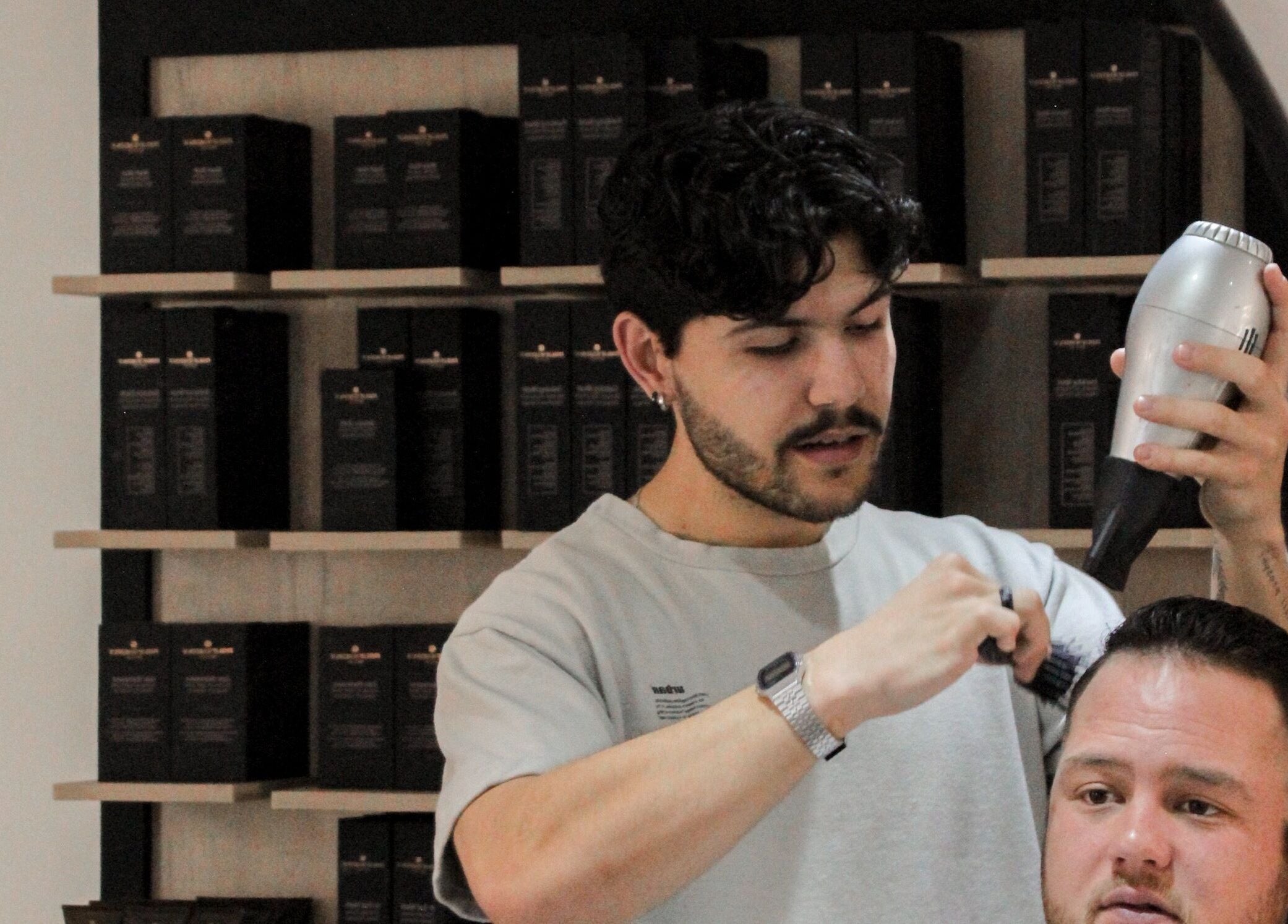Barber styling hair at The Barber in Bloemfontein, Free State, ZA.