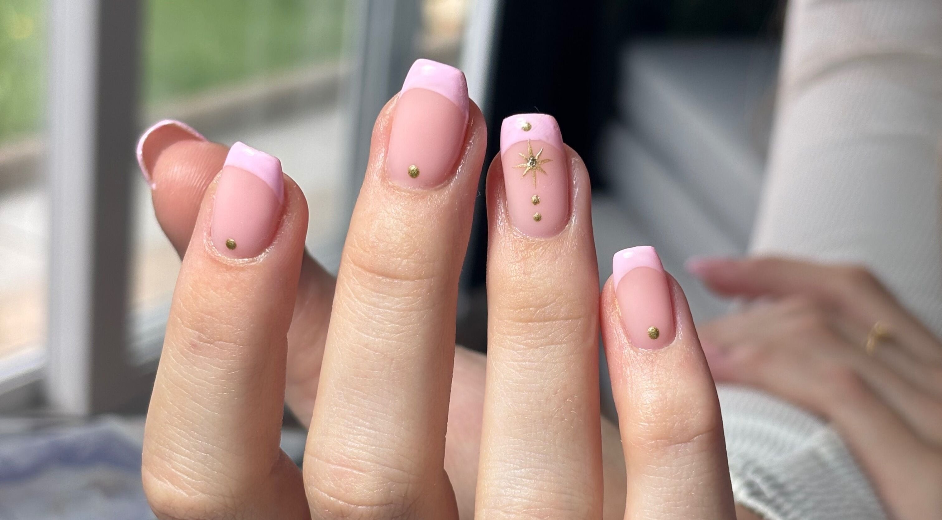 Close-up of elegant pink nail art with gold accents at JB Gels in Mountain Ash, Wales, GB.