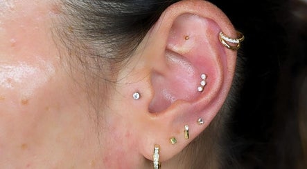 Ear piercings at Time Out Beauty, Piercing & Aesthetics in Chiddingfold, England, GB. Multiple earrings displayed.