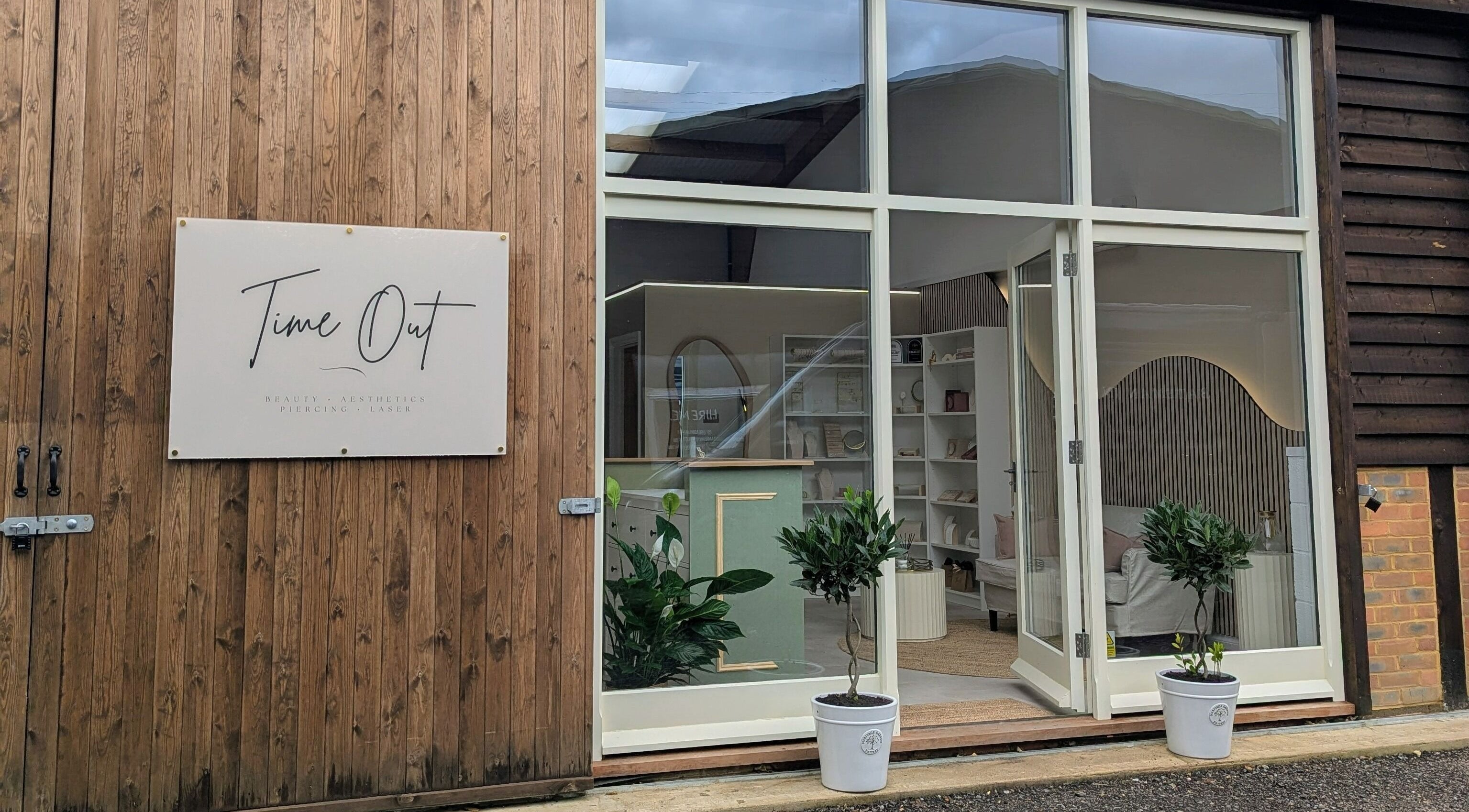 Elegant entrance of Time Out Beauty, Piercing & Aesthetics in Godalming, England, GB showcasing wooden facade.