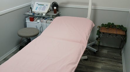 Comfortable treatment room at Unicorn Electrolysis, Columbus, Ohio, US, with pink-covered bed and equipment.
