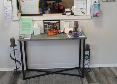 Chic entry setup at Unicorn Electrolysis in Columbus, Ohio, US, with table, brochures, and decor.