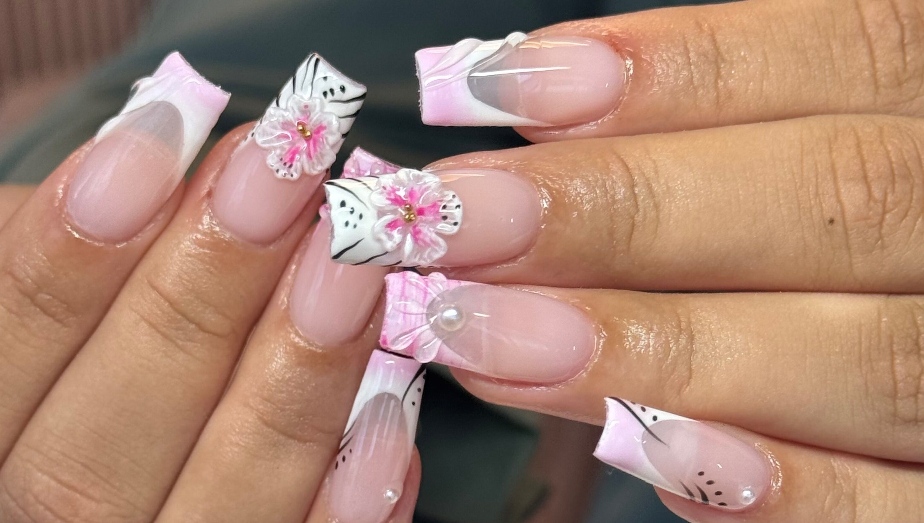 Exquisite floral nail art at Brahmaloka, High Wycombe, England, GB showcasing pink and white designs.