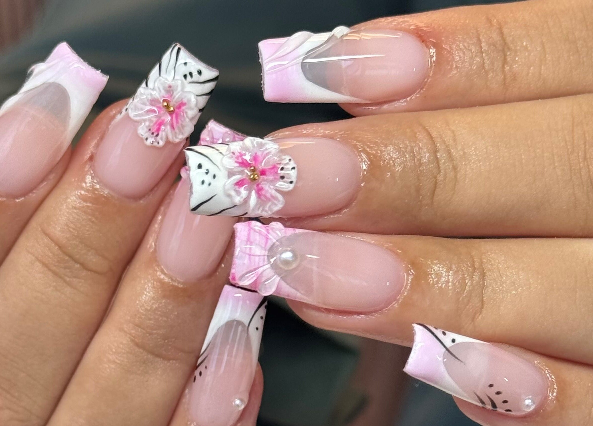 Exquisite floral nail art at Brahmaloka, High Wycombe, England, GB showcasing pink and white designs.