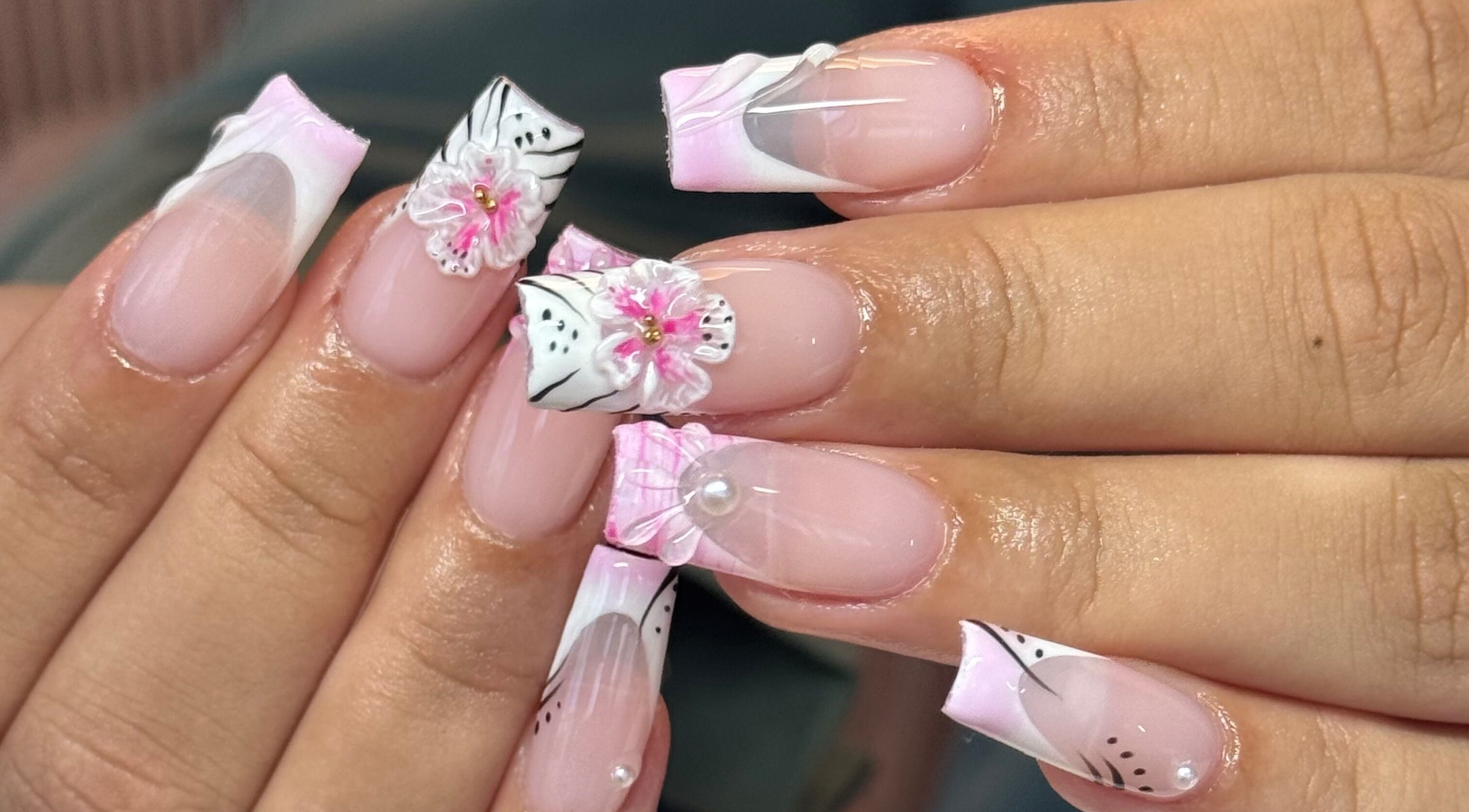 Exquisite floral nail art at Brahmaloka, High Wycombe, England, GB showcasing pink and white designs.