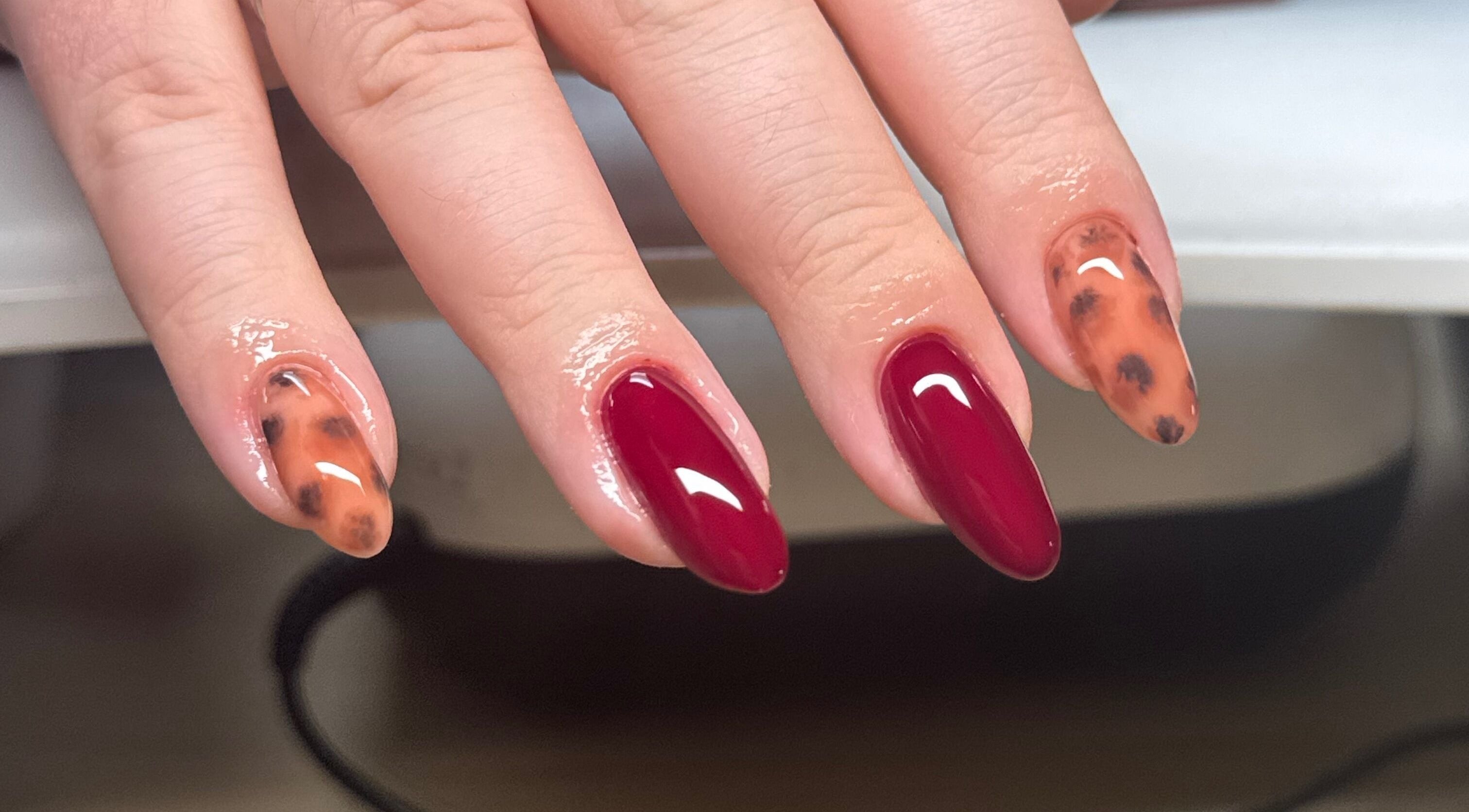 Stylish nail art with red and tortoiseshell design at Brahmaloka, High Wycombe, England, GB.