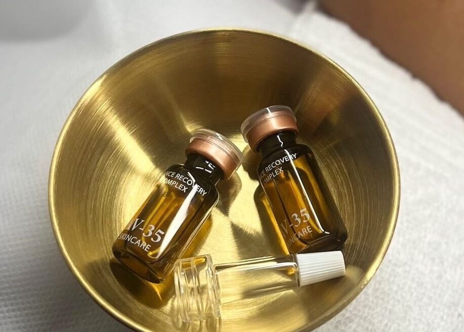 Elegant skincare vials in a gold bowl at ABY SKIN CARE, New York, New York, US.