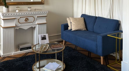 Cozy sitting area with blue sofa at Flávio Vilhais SkinLab, Lisboa, Lisboa, PT, enhancing relaxation.