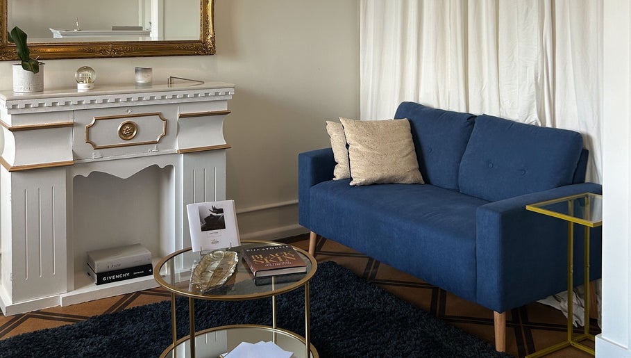 Elegant lounge at Flávio Vilhais SkinLab in Lisboa, Lisboa, PT featuring a blue sofa and ornate decor.