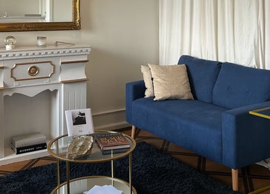 Elegant lounge at Flávio Vilhais SkinLab in Lisboa, Lisboa, PT featuring a blue sofa and ornate decor.