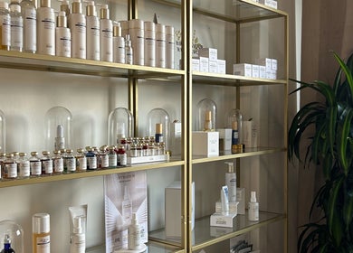 Premium skincare products on gold shelves at Flávio Vilhais SkinLab, Lisboa, Lisboa, PT.