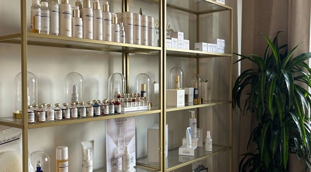 Premium skincare products on gold shelves at Flávio Vilhais SkinLab, Lisboa, Lisboa, PT.