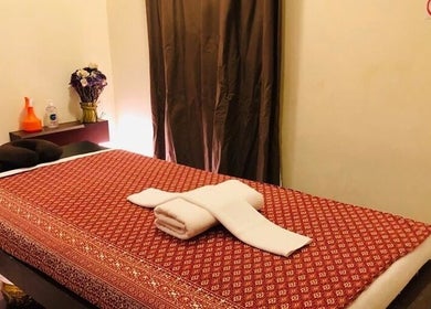 Cozy massage room at Sunshine Wellness SPA - Baniyas East, Abu Dhabi. Relaxing atmosphere with red decor.