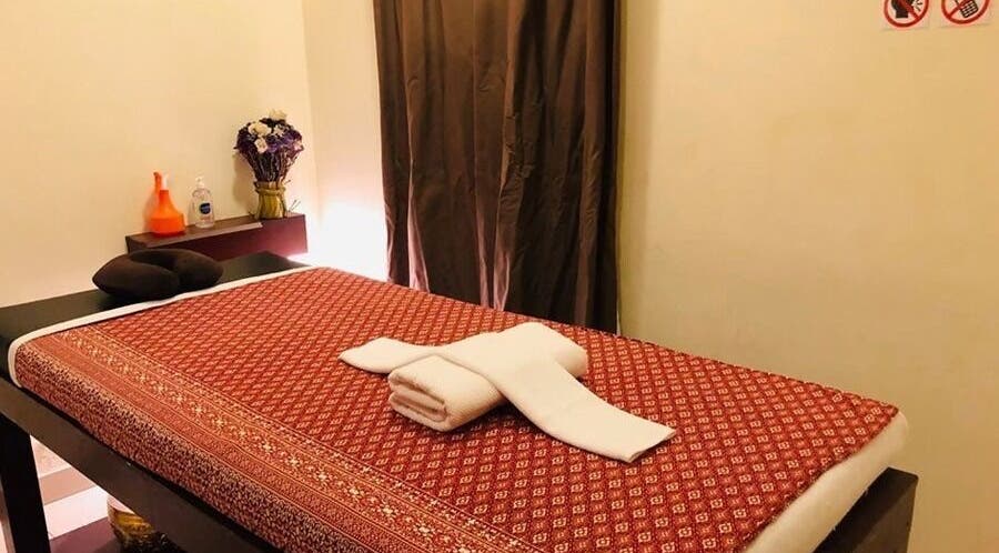 Cozy massage room at Sunshine Wellness SPA - Baniyas East, Abu Dhabi. Relaxing atmosphere with red decor.