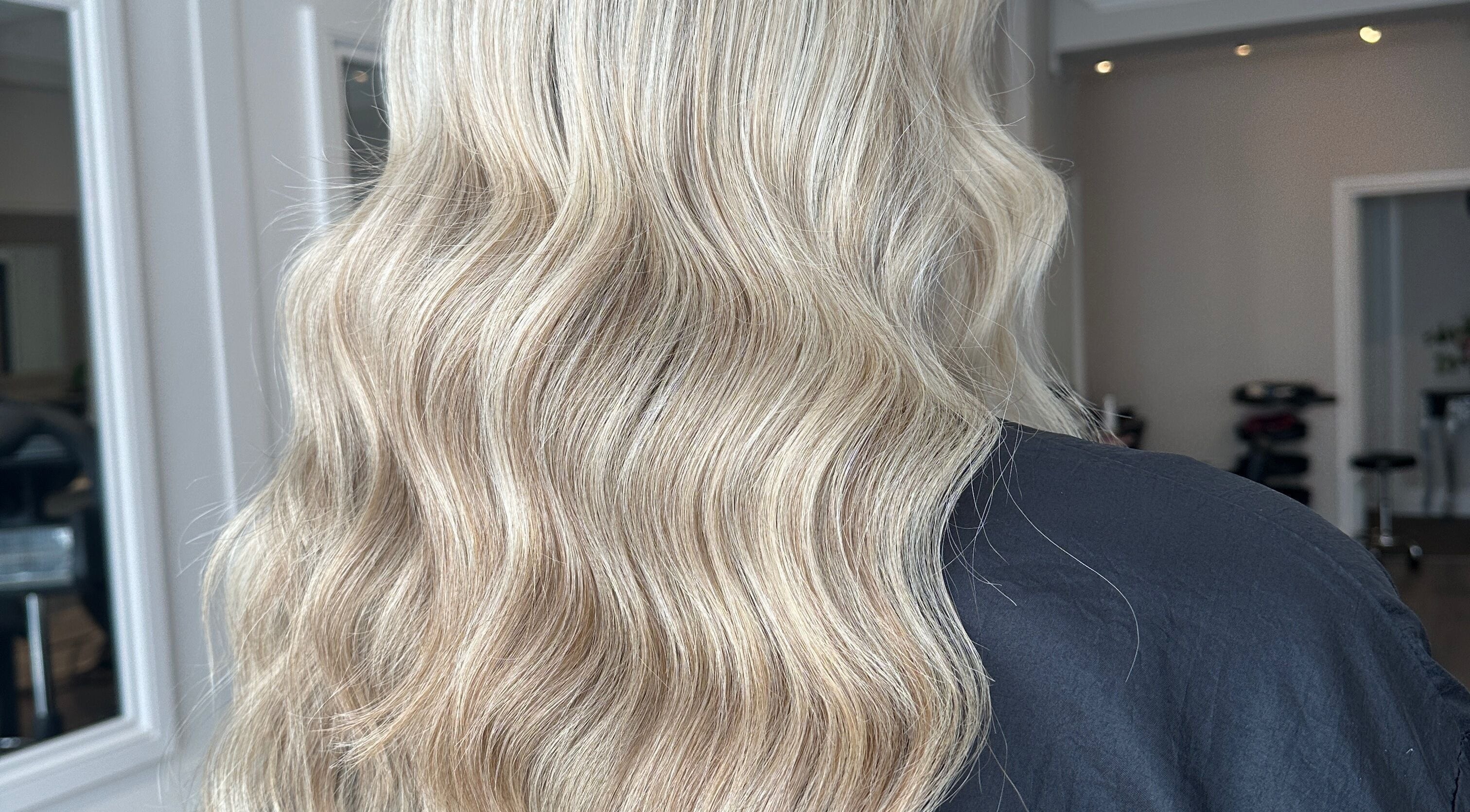 Elegant blonde waves styled at Joseph Rotchford Hair in Harrogate, England, GB, showcasing salon's expertise.
