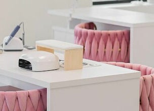 Elegant nail stations at Studio Boka, Highland Park, Illinois, US, with pink chairs and manicure tools.