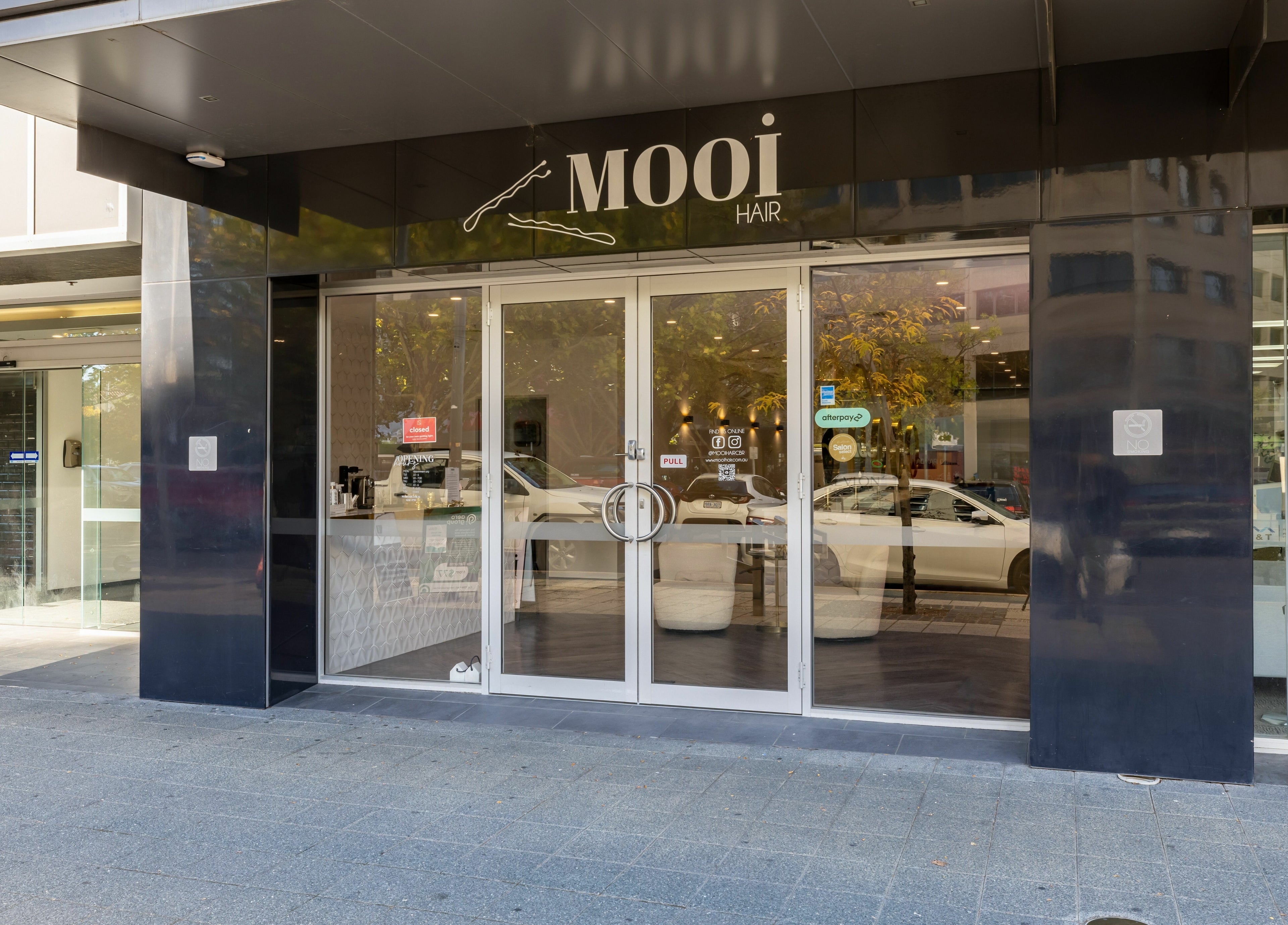 Front entrance of Mooi Hair CBR in Canberra, Australian Capital Territory, AU, with sleek glass doors.