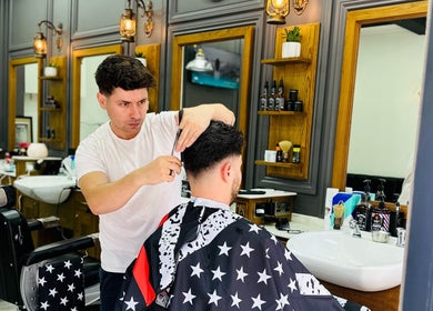 Barber styling hair at Vauxhall Barbers, London, England, GB. Modern interior and professional grooming.