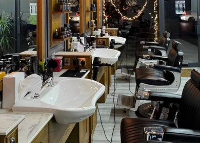 Vauxhall Barbers in London, England, GB features sleek chairs and well-lit modern decor, offering a refined grooming space.