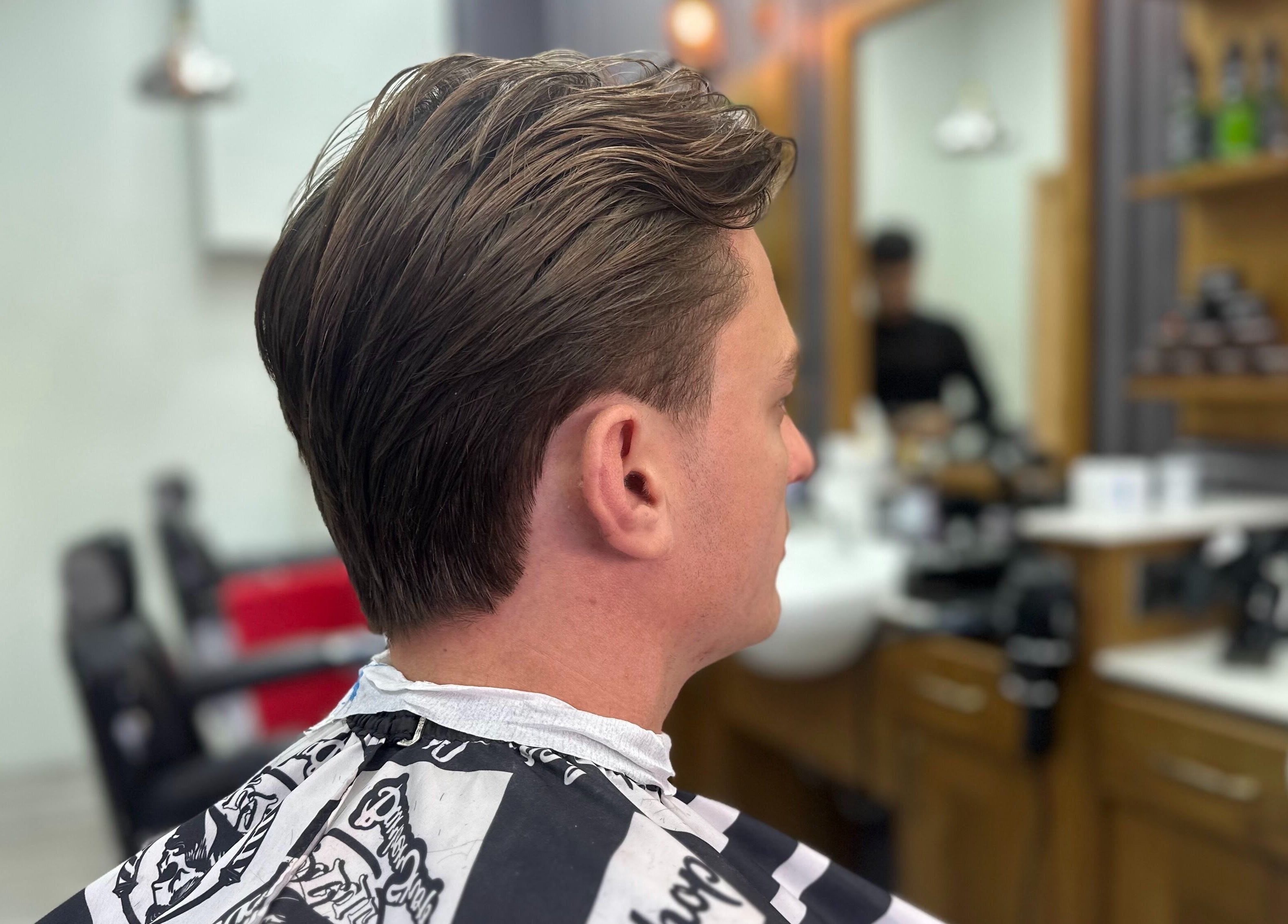 Man with a stylish haircut at Vauxhall Barbers, London, England, GB.