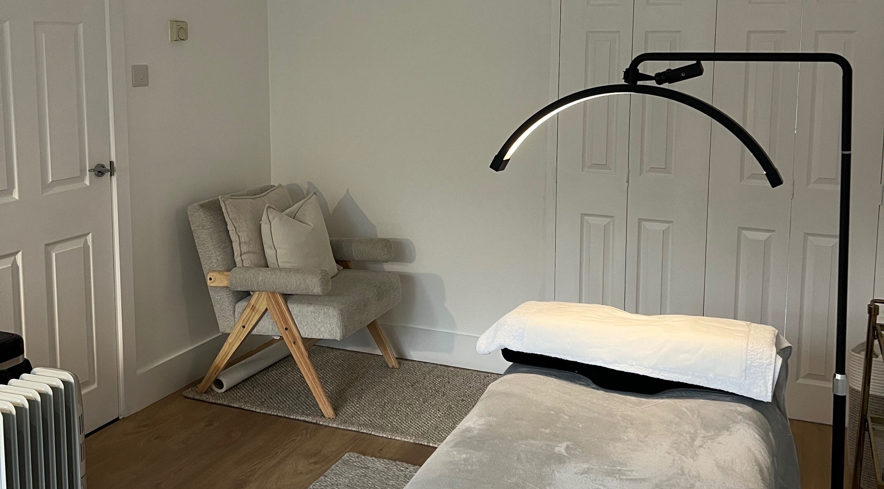 Calm treatment room at Beauté by Michèle, North Warnborough, England, GB featuring a cozy chair and massage table.