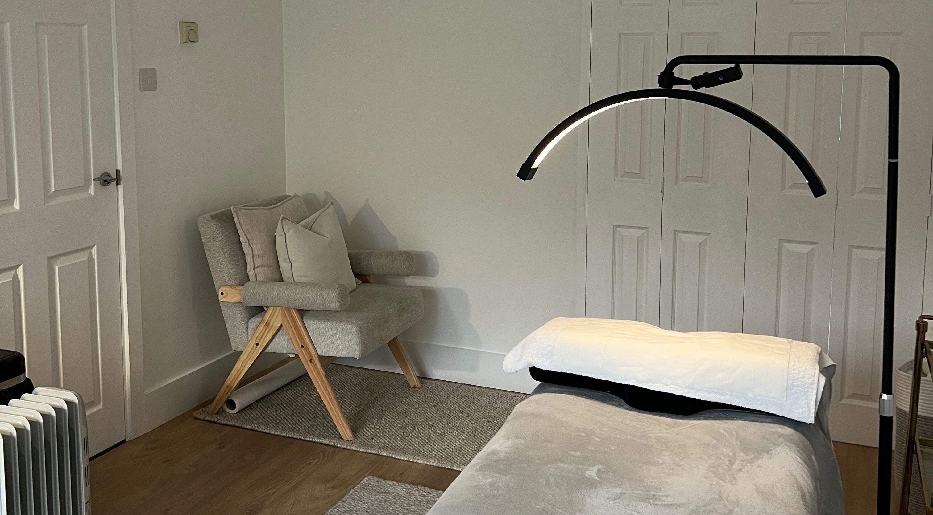 Calm treatment room at Beauté by Michèle, North Warnborough, England, GB featuring a cozy chair and massage table.