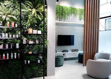 Stylish waiting area at AMERICAN WAX CENTER, Dubai, Dubai, AE with lush greenery and modern decor.