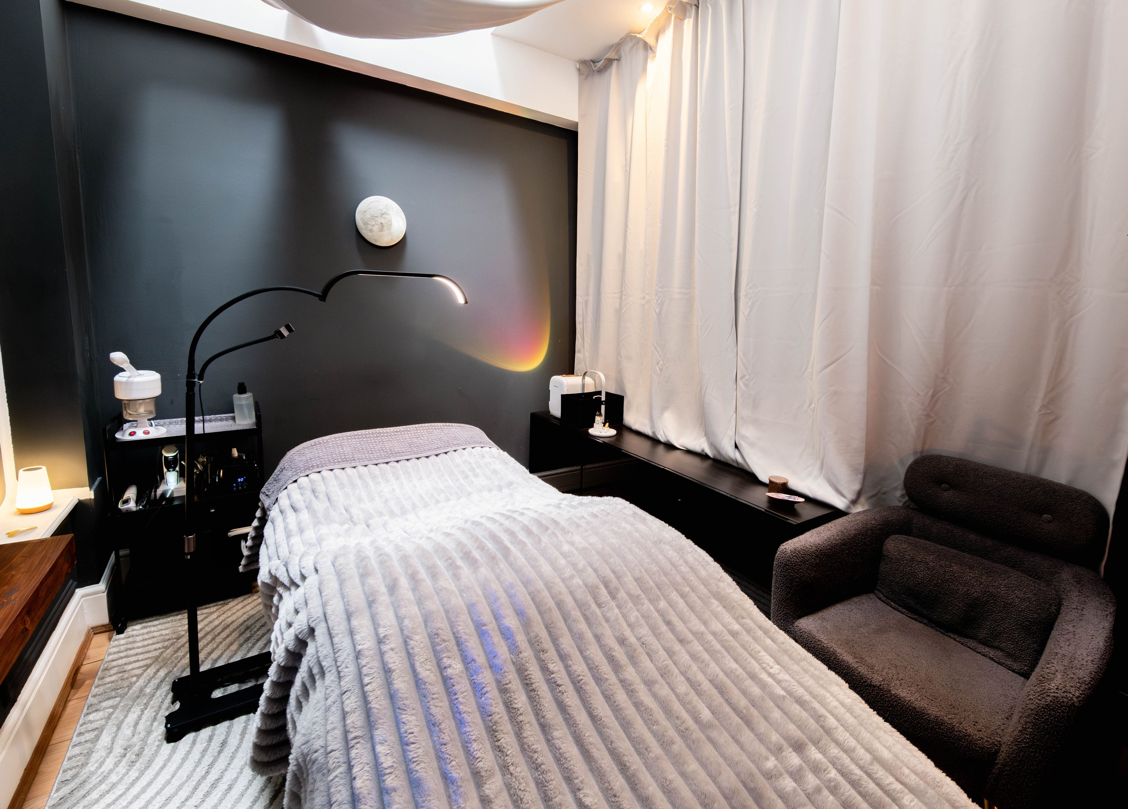 Relaxing spa room at Studio Luune, London, England, GB with plush chair and ambient lighting.