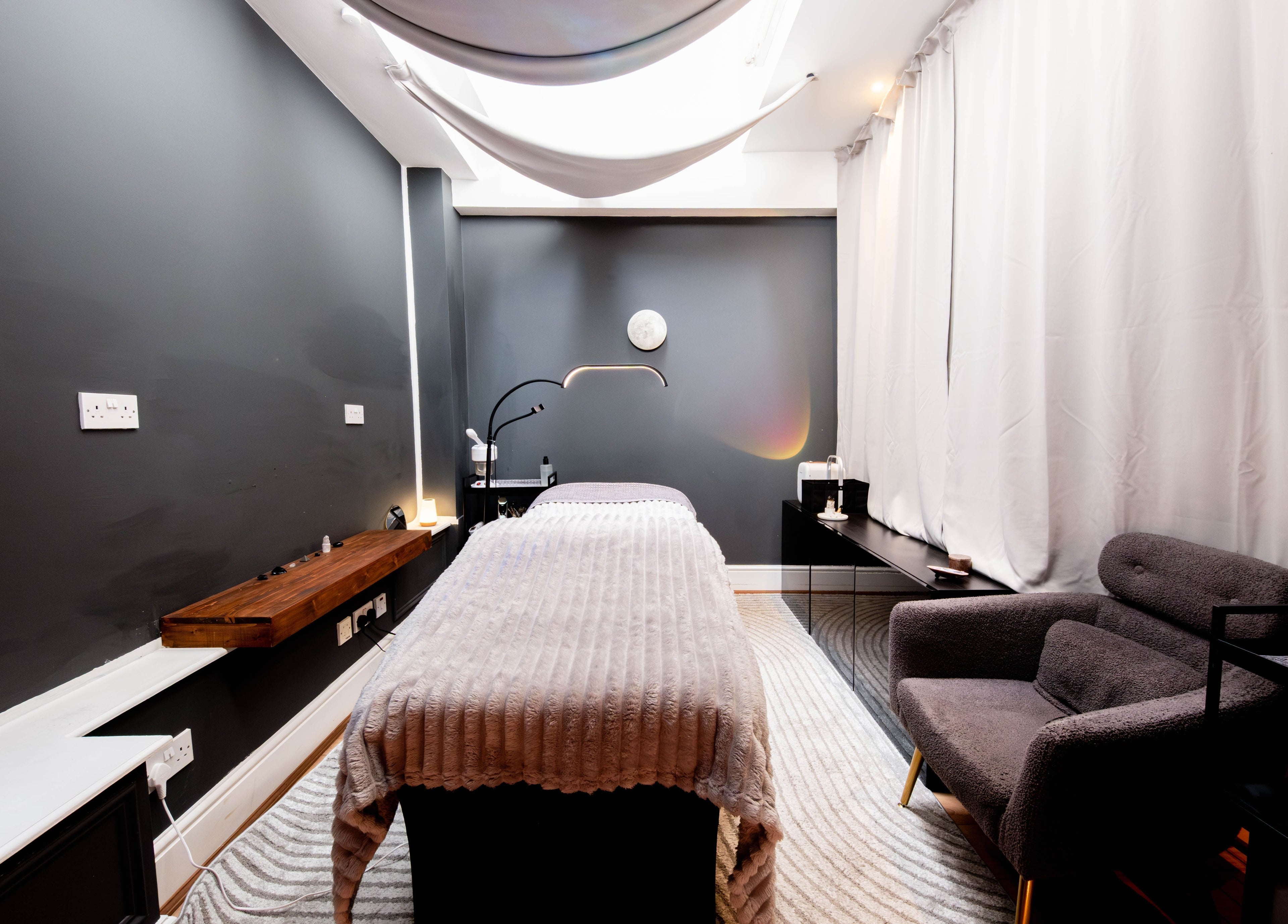 Tranquil therapy room at Studio Luune, London, England, GB with a massage table and cozy armchair.