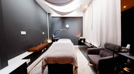 Tranquil therapy room at Studio Luune, London, England, GB with a massage table and cozy armchair.