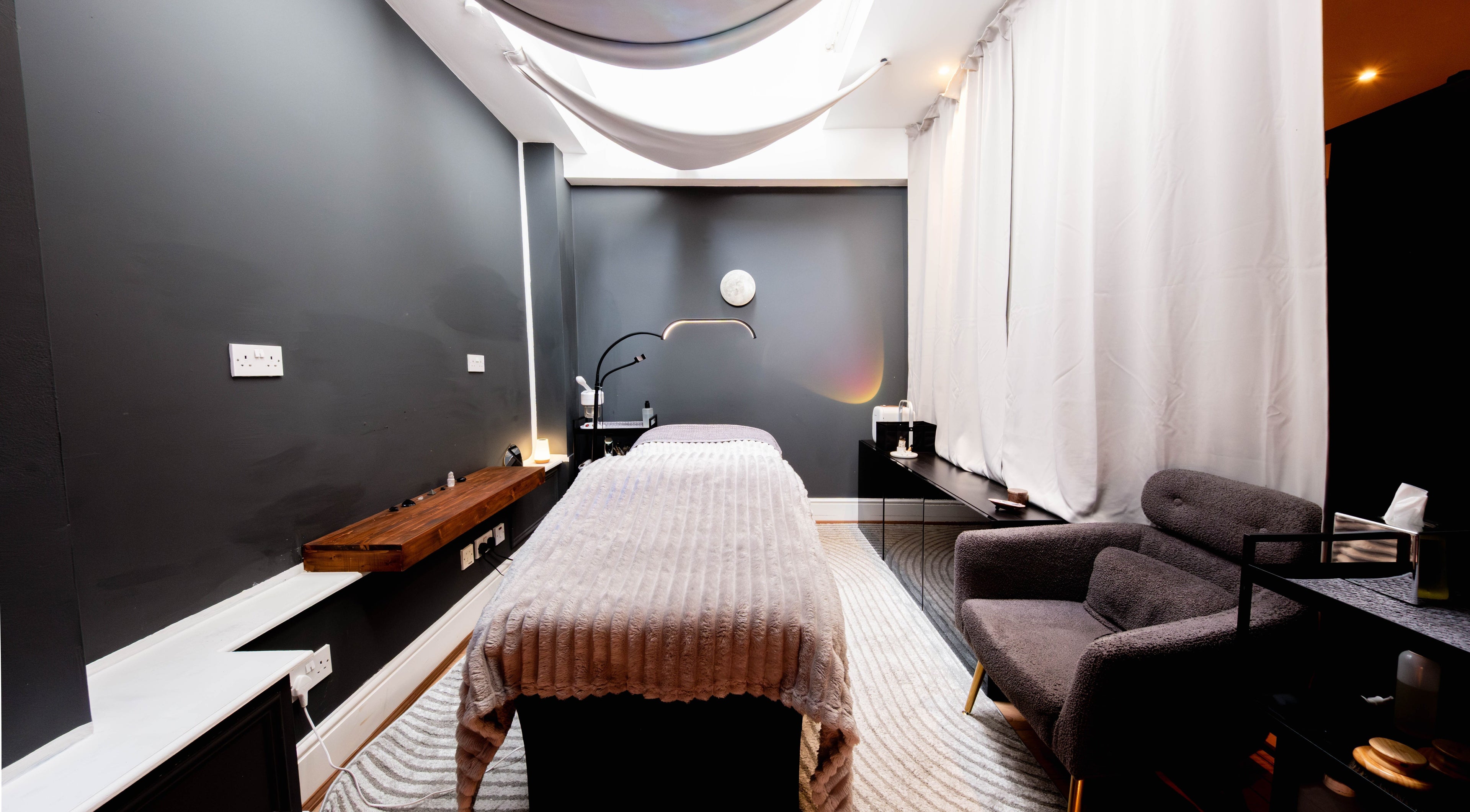 Tranquil therapy room at Studio Luune, London, England, GB with a massage table and cozy armchair.