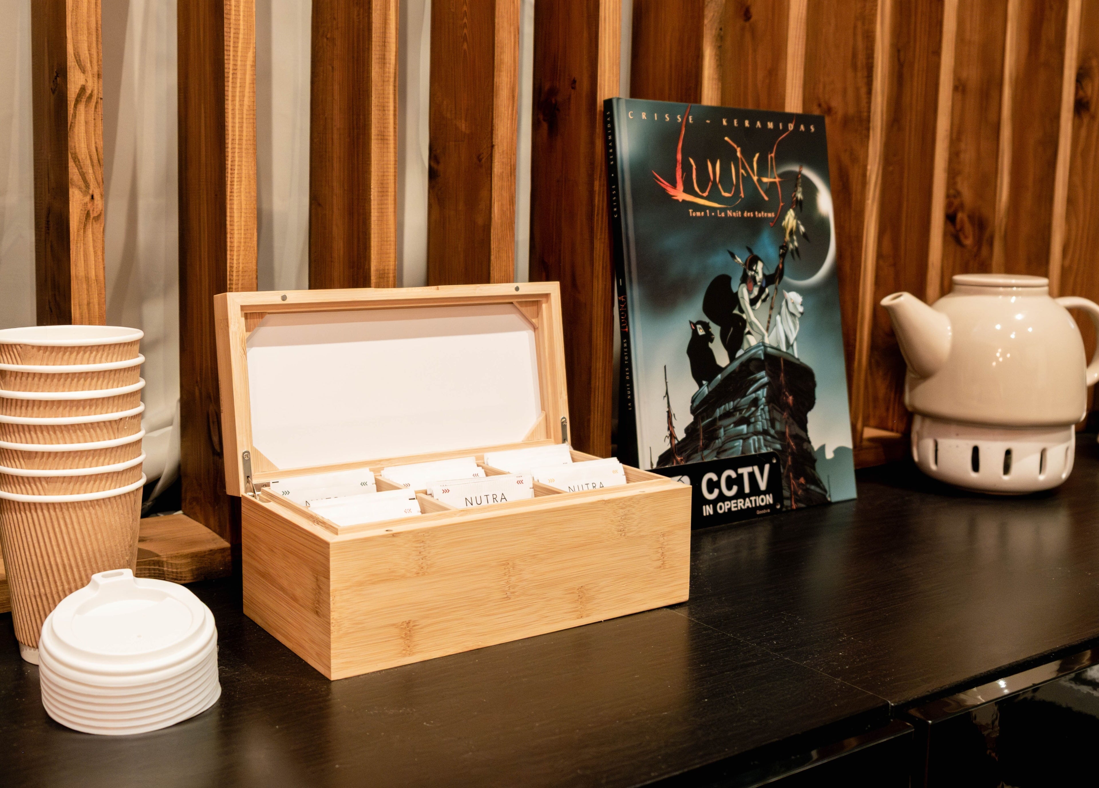 Tea setup at Studio Luune, London, England, GB with cups, teapot, and tea box on a wooden shelf.