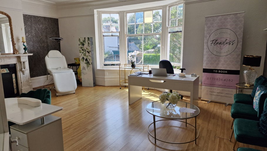 Bright, elegant treatment room at Flawless Aesthetic Creations, Deal, GB with chic decor and ample natural light.