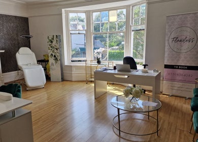 Bright, elegant treatment room at Flawless Aesthetic Creations, Deal, GB with chic decor and ample natural light.