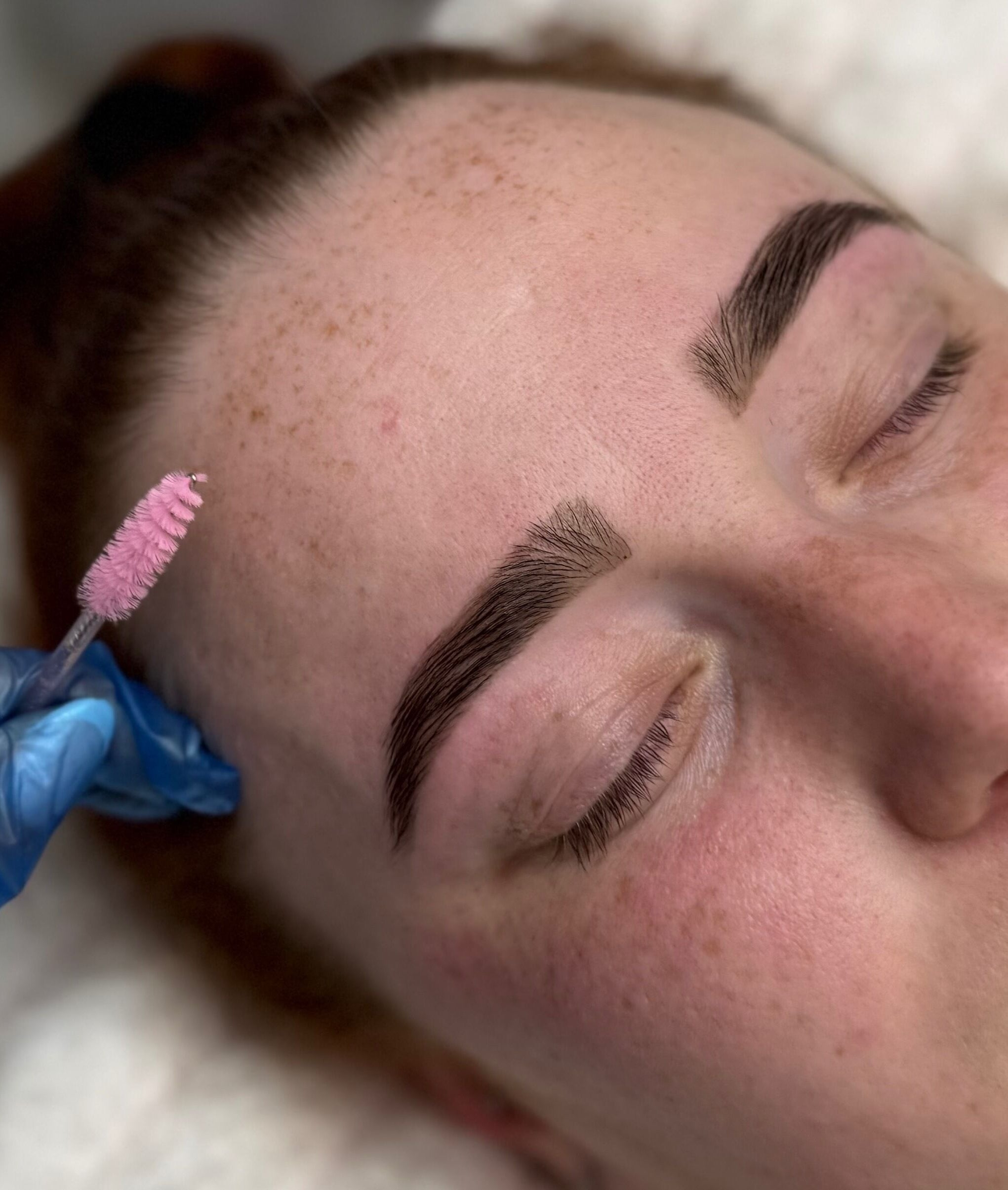 Enhance brows at Lash Tee in Desborough, England with precise treatment using pink brush tool.