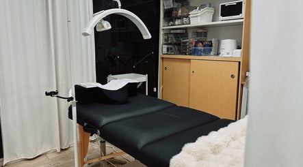 Relaxing treatment room at HIME STUDIO / He Mēi “姫” in Singapore, SG with a cozy massage bed and warm lighting.