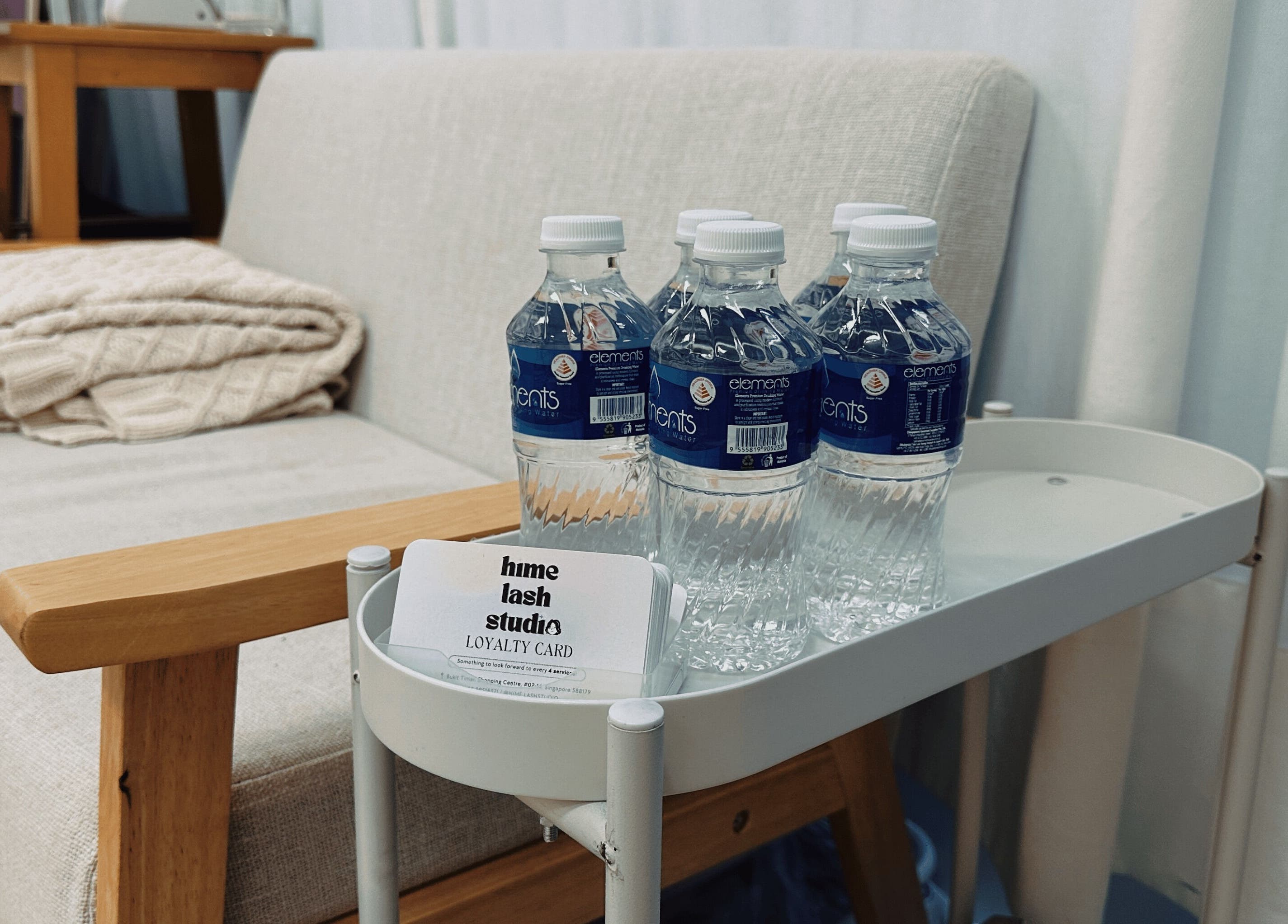 Relaxing seating area at Hime Studio / He Mēi “姫” in Singapore, SG with bottled water and loyalty card.